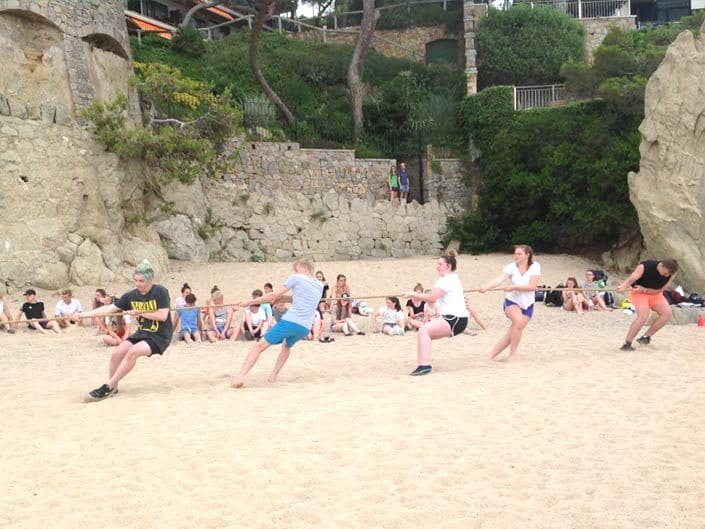 Students having a tug of war competition on the beach