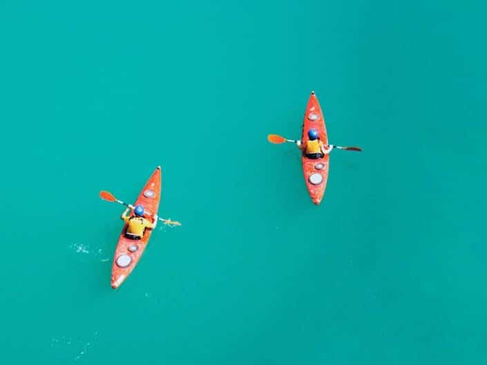Two kayakers on calm azure sea surface