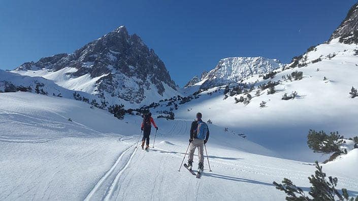 Two skiers on a mountain pass